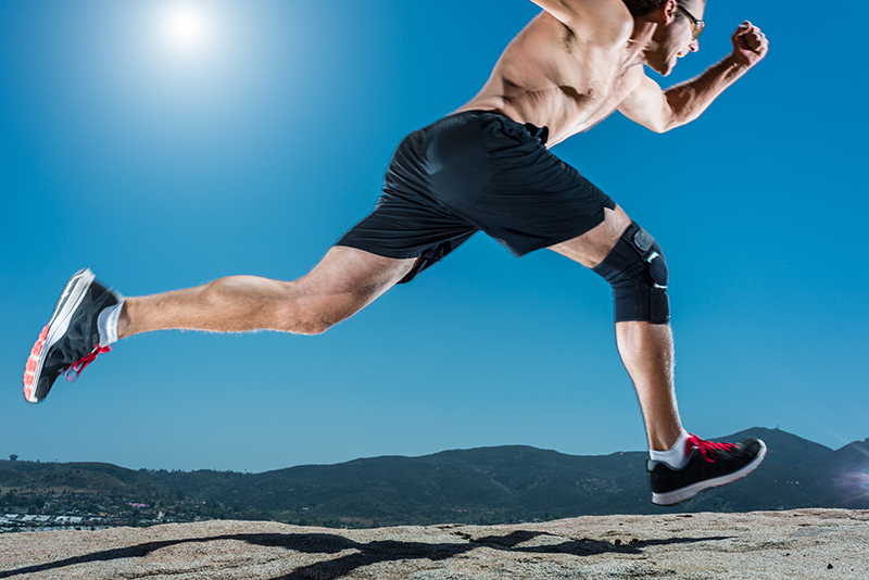 Knee Brace Running Up A Granite Boulder In The Mountains